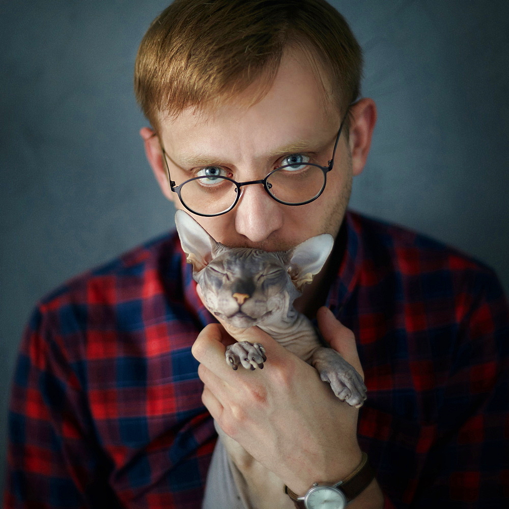 Caucasian man kissing kitten