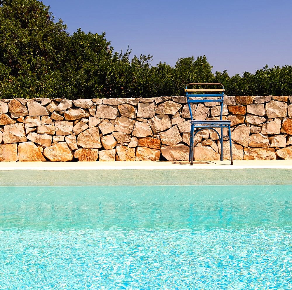 Italy, Apulia, Brindisi Province, Ostuni, Chair next to swimming pool