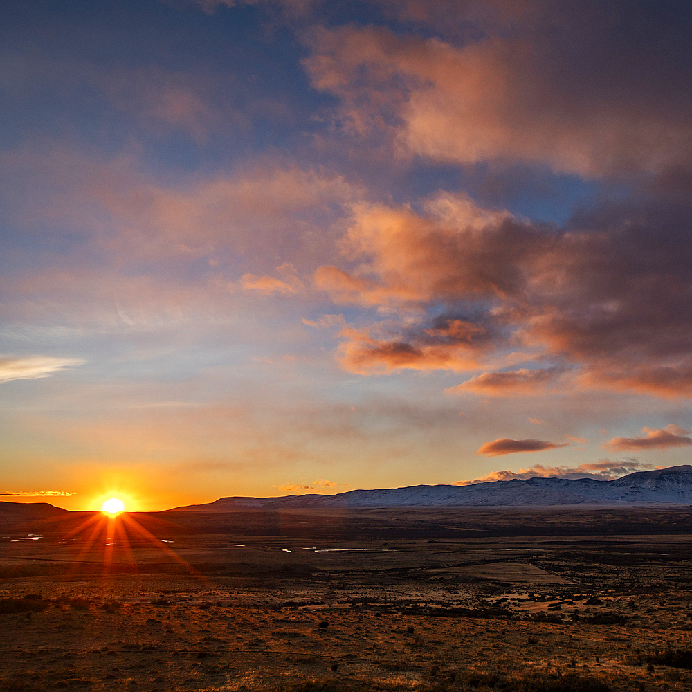 Argentina, Santa Cruz, El Calafate, Sun rising above plain landscape with mountains in distance