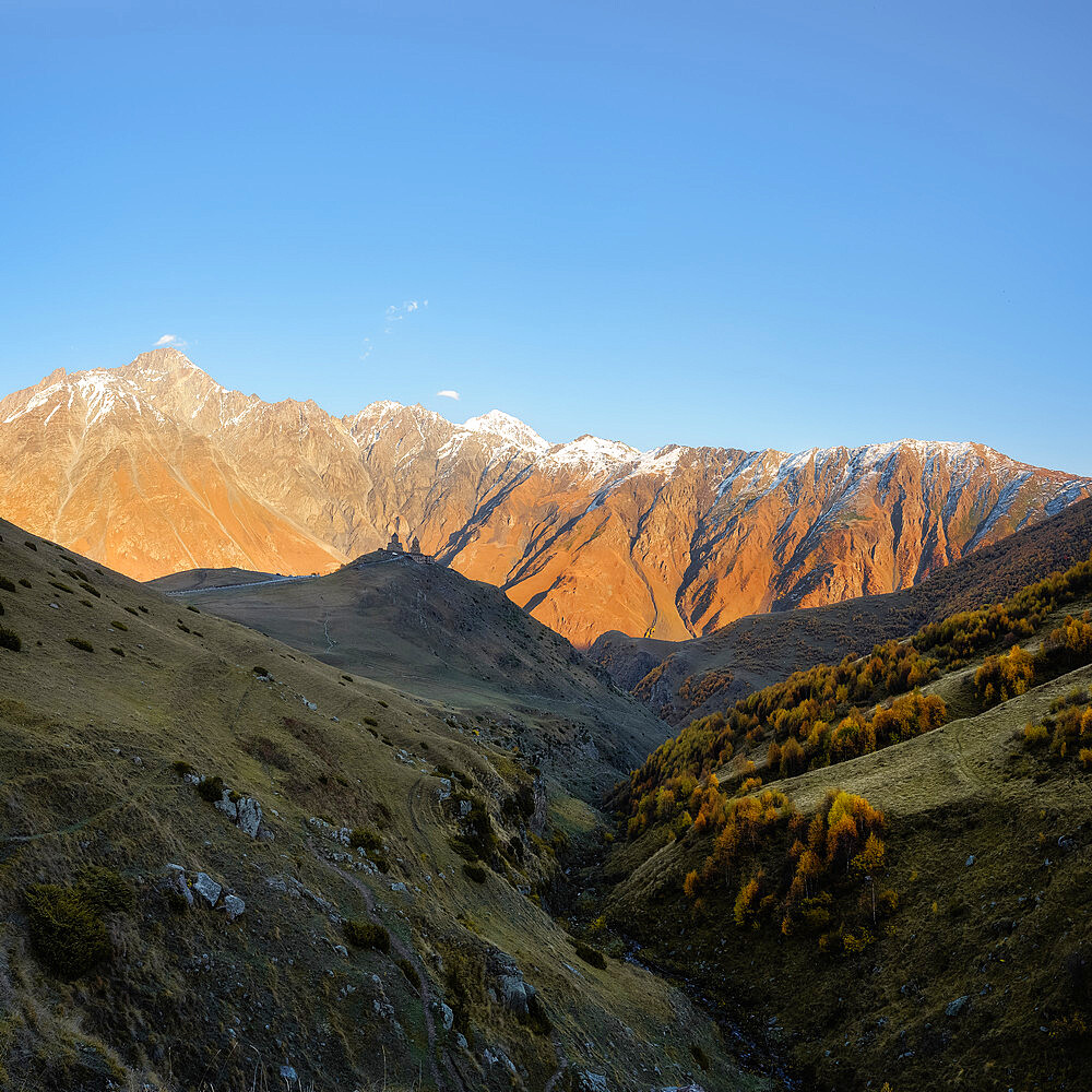 Fall view of Gergeti Trinity Church at sunset, Kazbegi, Georgia (Sakartvelo), Central Asia, Asia