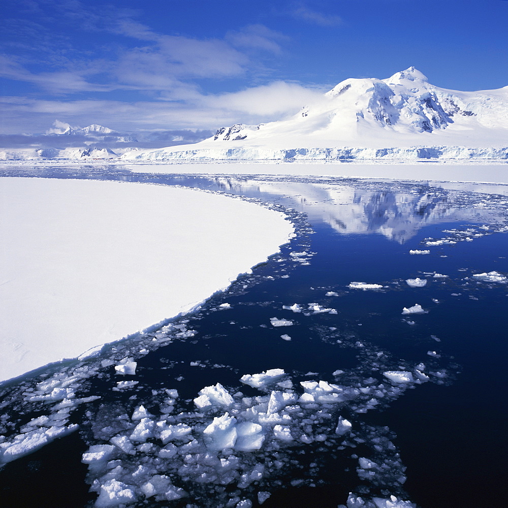 Reflections in icy sea of snow covered mountain, on the west coast of the Antarctic Peninsula, Antarctica, Polar Regions