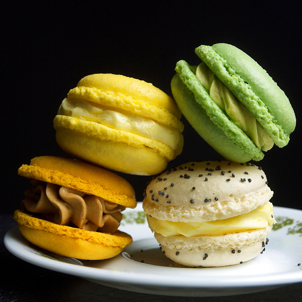 Four macarons on a black background