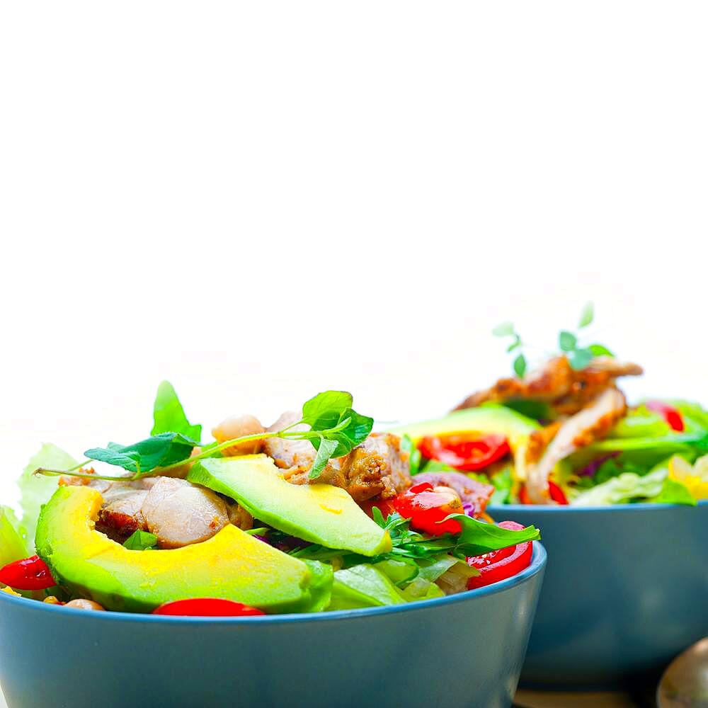 Fresh and healthy Chicken Avocado salad over rustic wood table