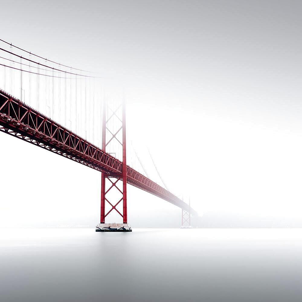 Minimalist long exposure of the Golden Gate Bridge's little sister. The Ponte 25 de Abril bridge over the Tagus River in Lisbon, Portugal, Europe