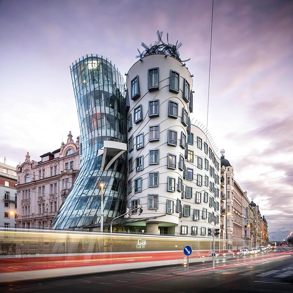 Rush hour with tram at colourful sunset at the Dancing House in Prague, Czech Republic, Europe