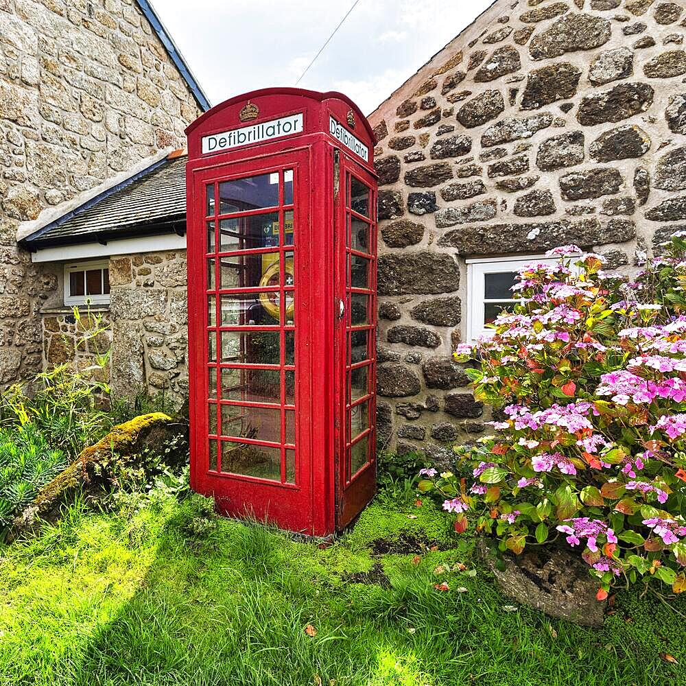 Red telephone box with defibrillator inscription, Cornwall, England, Great Britain