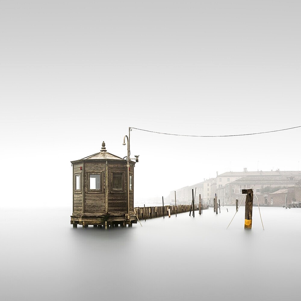 Long exposure in fog of a small wooden house where the water level is measured to monitor the flood in Venice, Italy