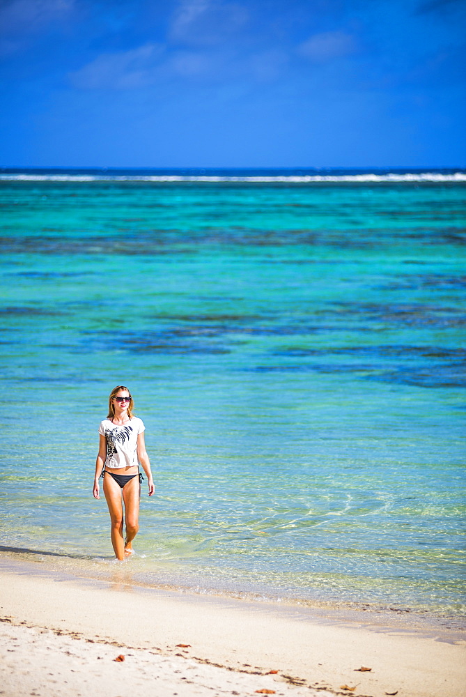 Woman walking along a tropical beach, Rarotonga Island, Cook Islands, South Pacific, Pacific