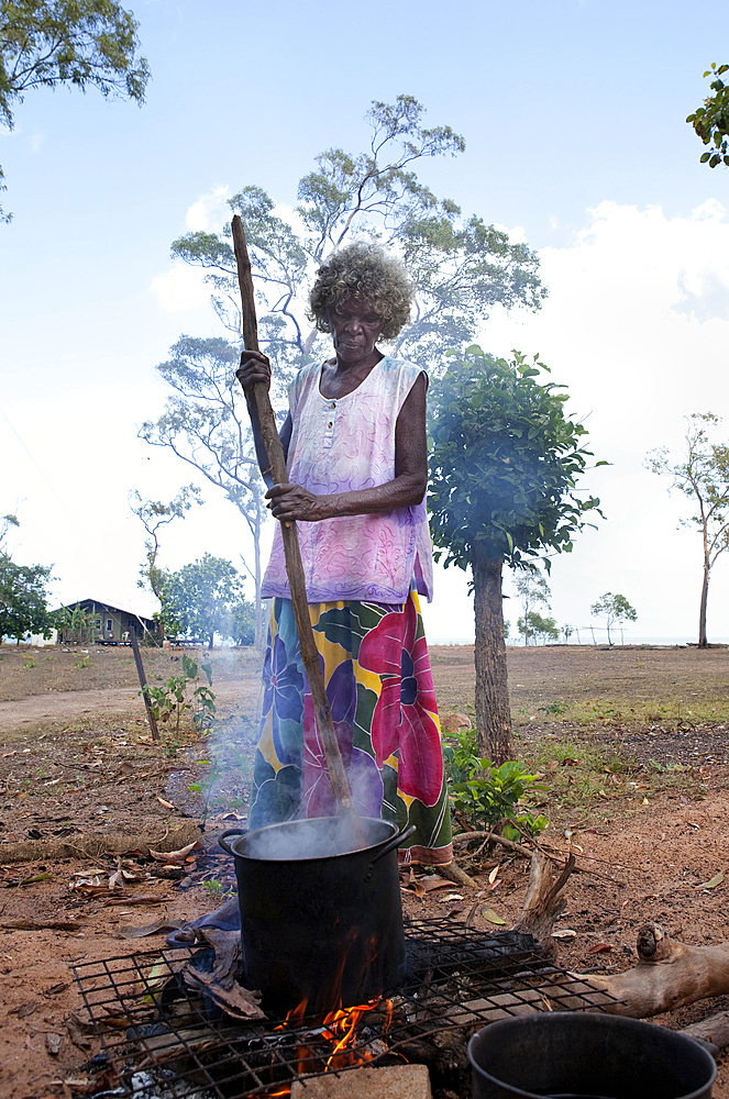 Aboriginal Yolngu elder stirs freshly dyed pandanus fronds to be used for basket making at Nyinyikay Homeland, East Arnhem Land, Northern Territory, Australia, Pacific