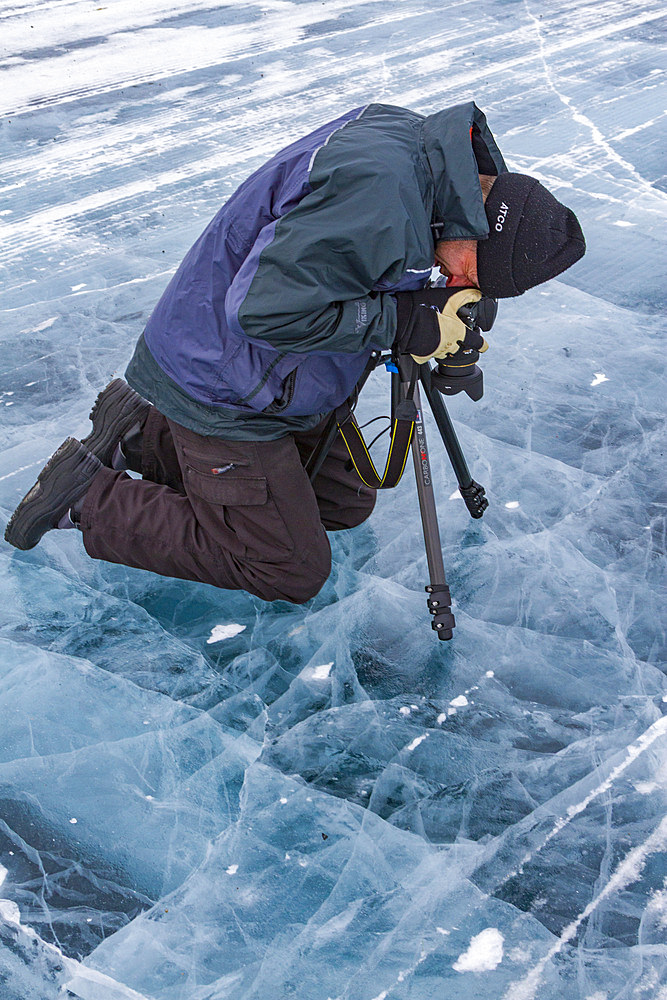 Canadian photographer Gilles Pucheu on the frozen solid Great Slave Lake, Northwest Territories, Canada.