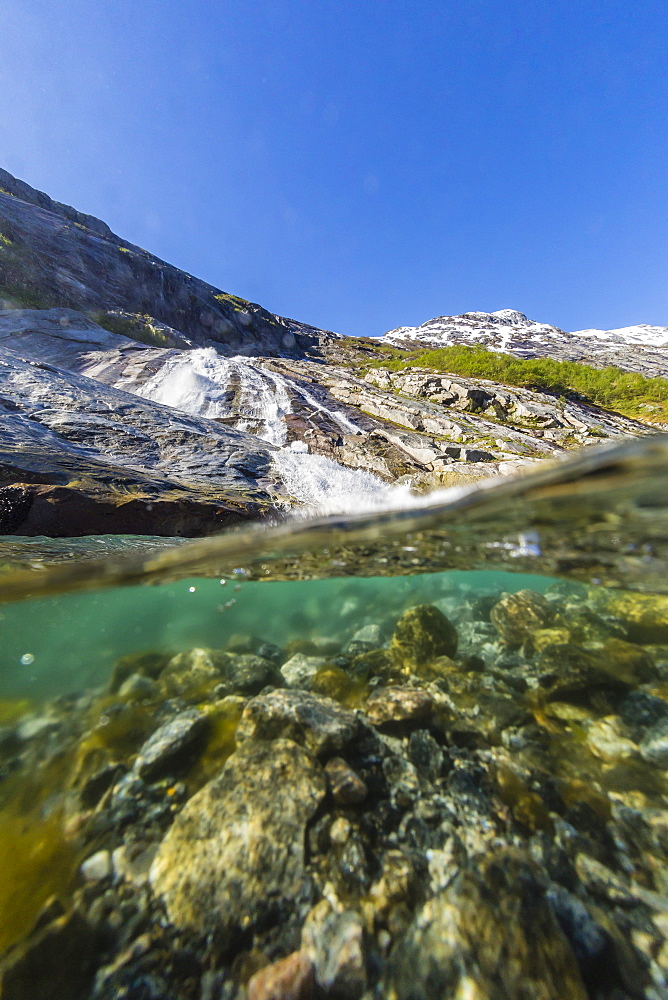 Above and below view of ice melt waterfall cascading down in Svartisen National Park, Melfjord, Nordfjord, Norway, Scandinavia, Europe