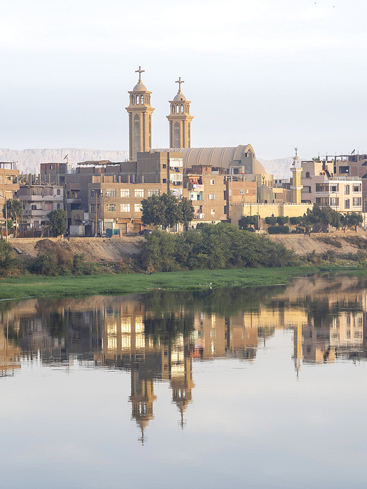 A view of the shoreline along the upper Nile River, with town and church reflection, Dendera, Egypt, North Africa, Africa