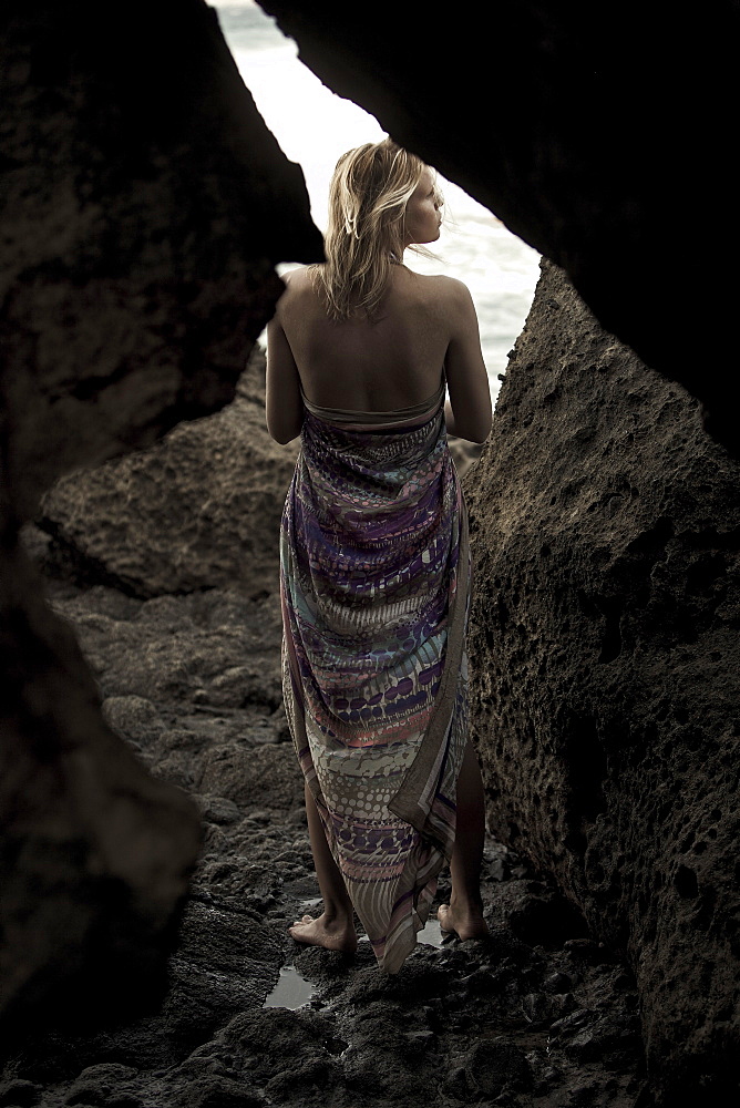 Young woman on a rock at the sea, Fuerteventura, Spain