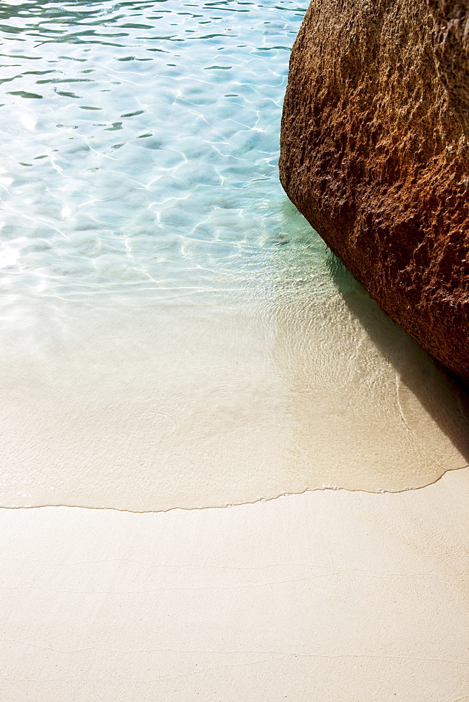 Wave washing around rock on fine white sandy beach, Similan Islands, Andaman Sea, Thailand