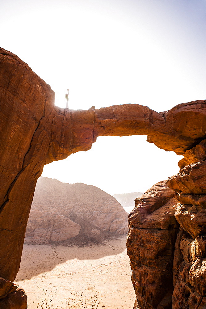 Woman practising yoga on Jabal Umm Fruth Rock Bridge, Wadi Rum, Jordan, Middle East