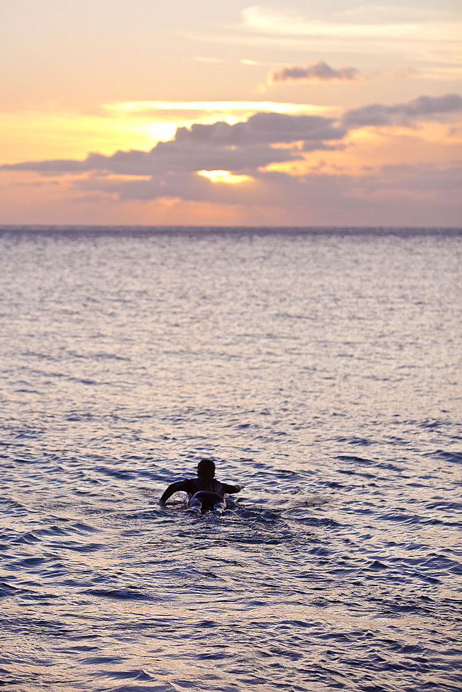 Female surfer paddling, Praia, Santiago, Cape Verde