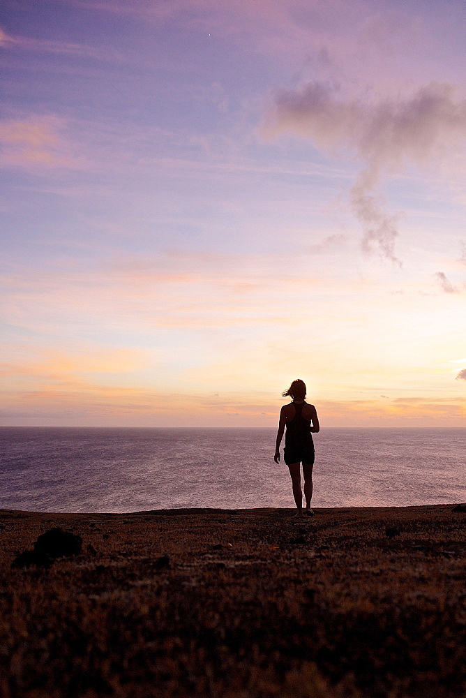 Woman looking at sunset over the ocean, Praia, Santiago, Cape Verde