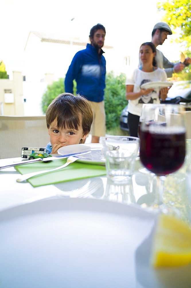 Boy sitting at a table, Perols, Montpellier, Herault, Languedoc-Roussillon, France