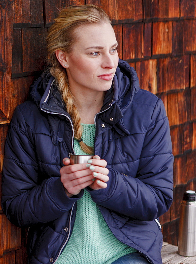 Young woman holding a mug, Spitzingsee, Upper Bavaria, Germany