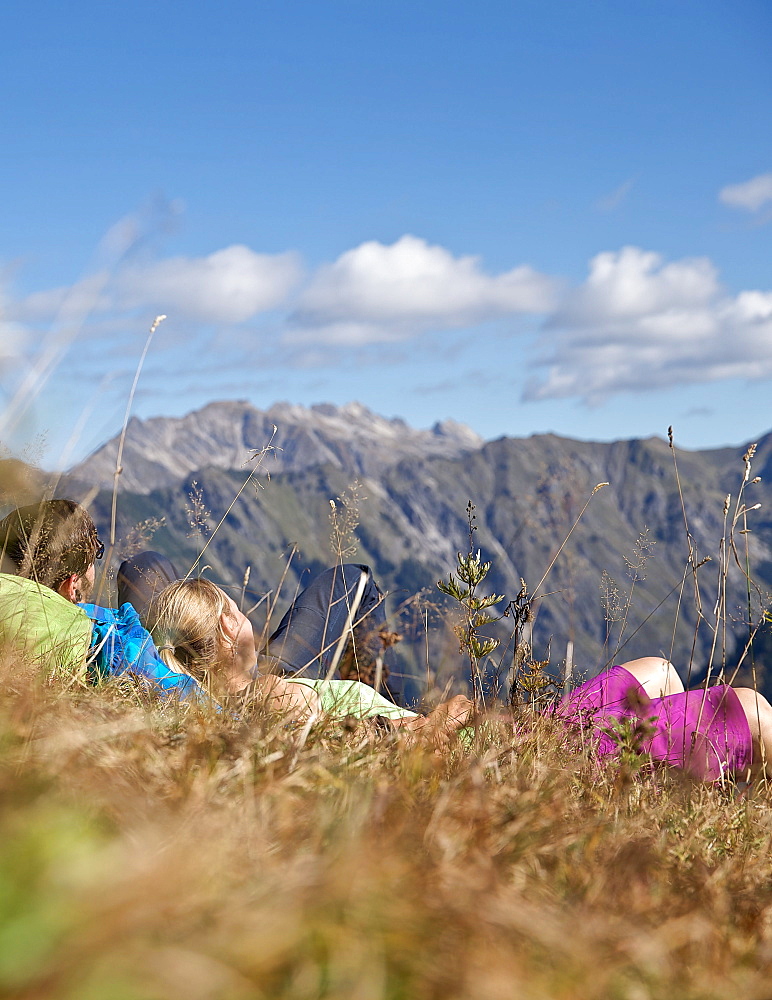 Couple having a break from hiking on a sunny day, Oberstdorf, Bavaria, Germany