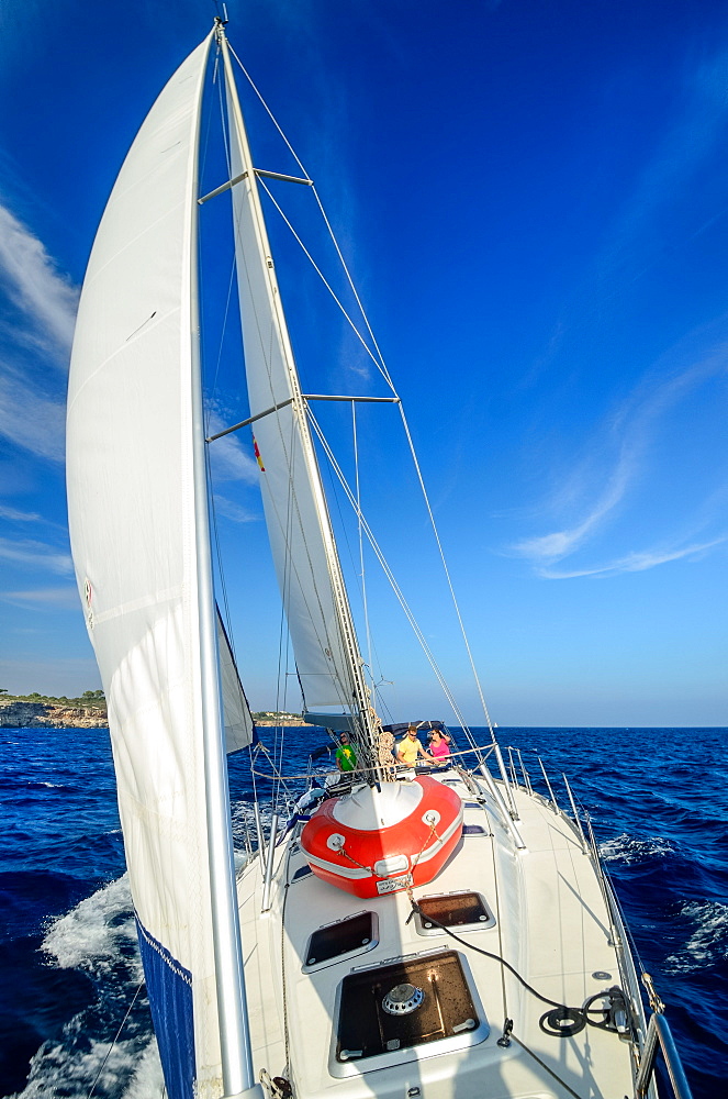 The crew consisting of young women and men sailing a sailing yacht along the northern shore of Mallorca, Balearic Islands, Spain, Europe