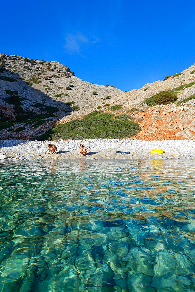 Young women on the beach of a lonely bay on Syphos (Sifnos), Greek Islands, Aegean, Cyclades, Greece