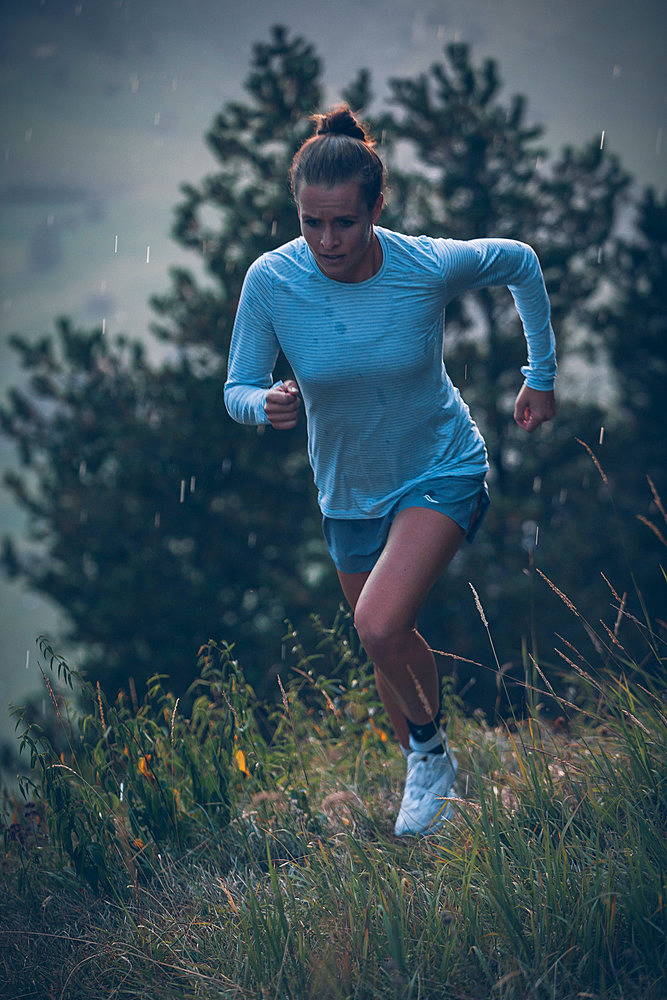 Young woman runs in the evening mood at Falkenstein, Allgäu, Bavaria, Germany