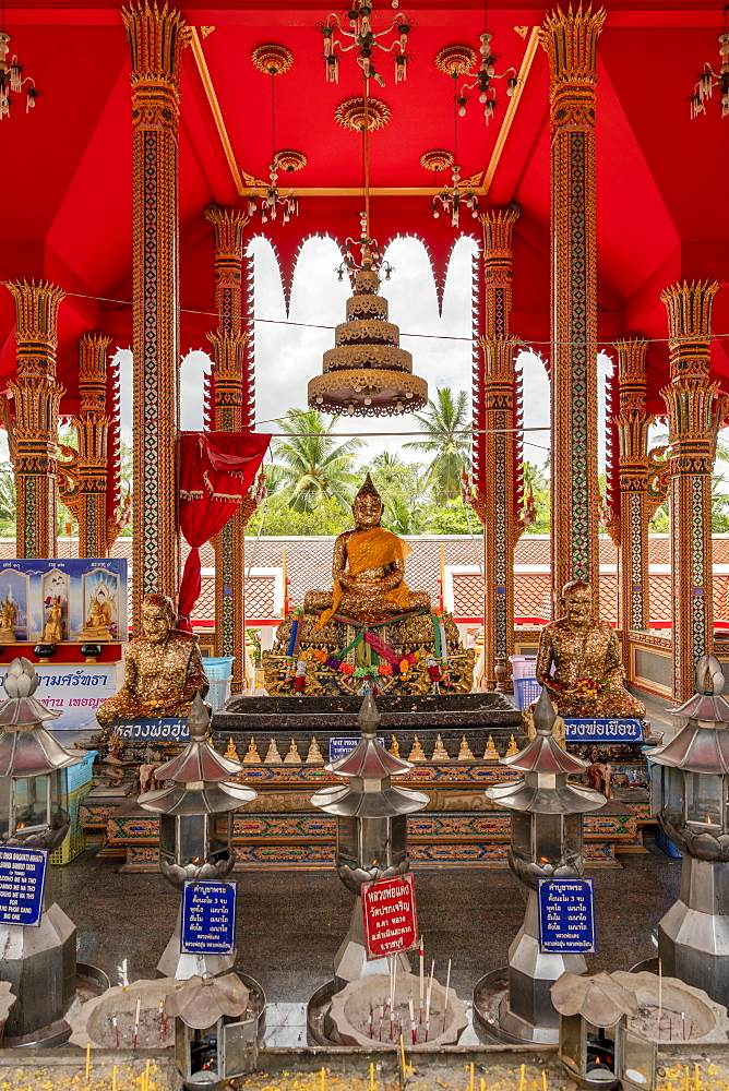 Three Buddha statues and offerings in temple, Otop Temple, Bangkok, Thailand