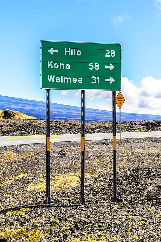 Road sign showing miles to destinations from the Mauna Kea Access Road at its junction with the Daniel K. Inouye Highway (in the picture) also known as the Saddle Road and Hawaii State Route 200 on the Big Island of Hawaii, USA during the summer, Island of Hawaii, Hawaii, United States of America