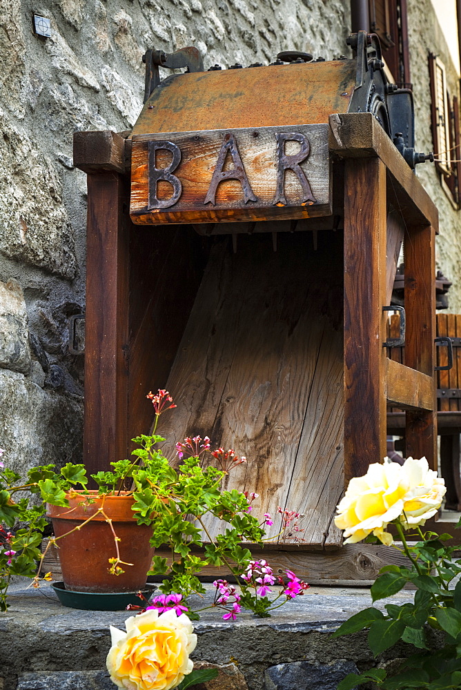 Old wooden bar equipment with flowers in pots, Dolonne, near Courmayeur, Aosta Valley, Italy