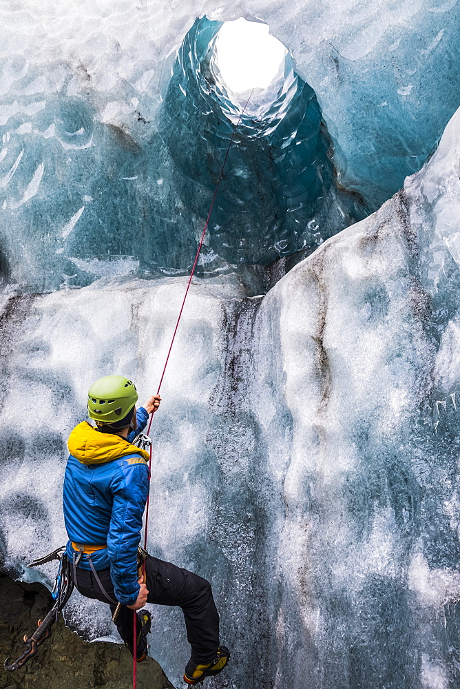 Man exploring an ice cave, South Coast, Iceland