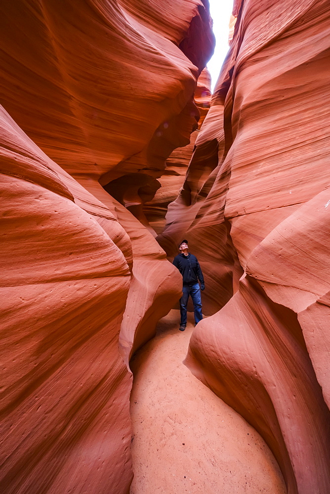 Man standing in a Slot Canyon known as Canyon X, near Page, Arizona, United States of America