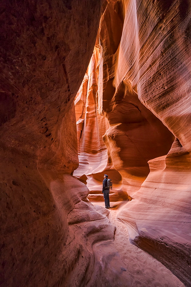 Man standing in a Slot Canyon known as Canyon X, near Page, Arizona, United States of America