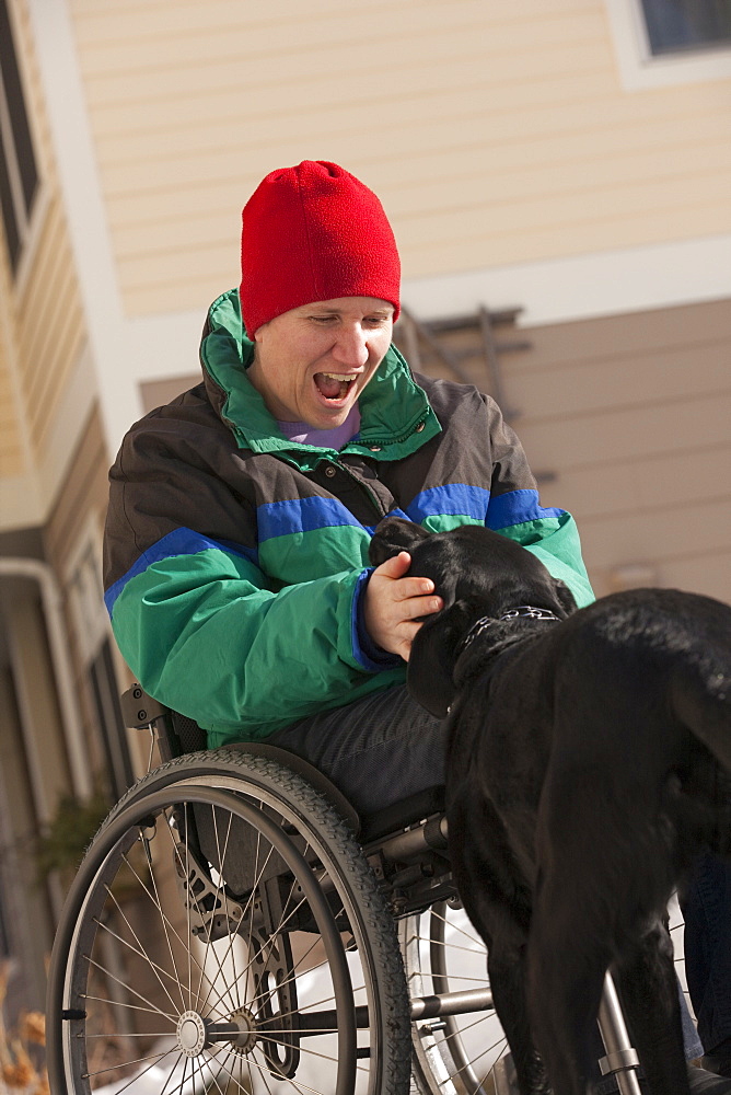 Woman with multiple sclerosis playing with a service dog