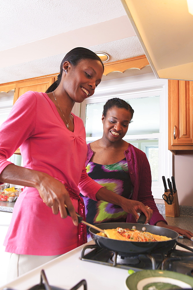 Two sisters cooking in the kitchen, one with learning disability