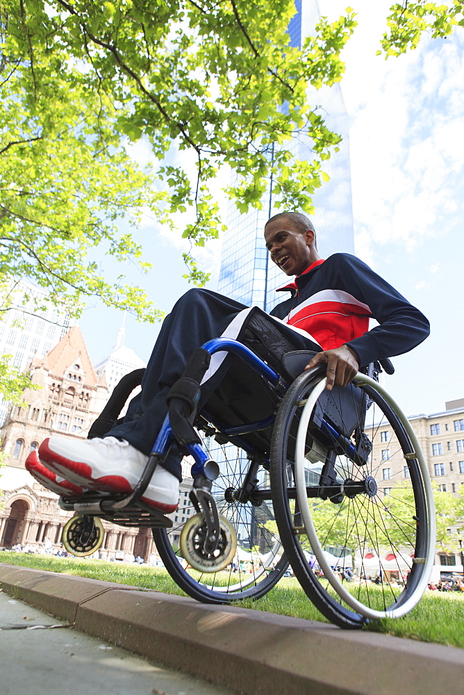 Man in wheelchair who had Spinal Meningitis going over a curb