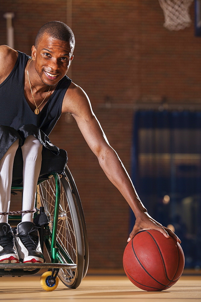 Man who had Spinal Meningitis in wheelchair picking up basketball