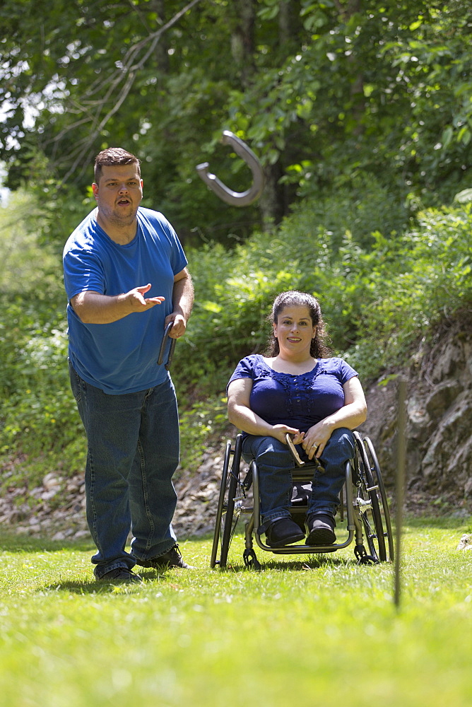 Woman with Spina Bifida in a wheelchair playing horseshoes with her husband