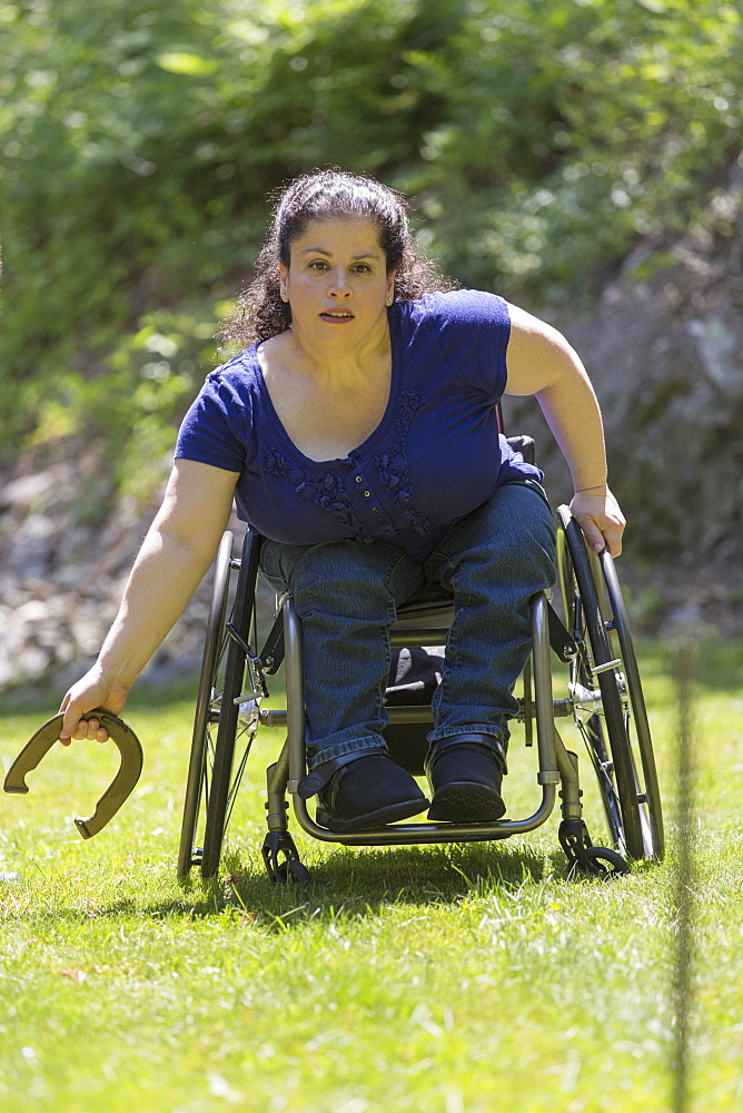 Woman with Spina Bifida in a wheelchair playing horseshoes