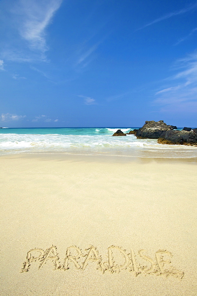 The Word Paradise Written In White Sand On A Beach With Turquoise Ocean Water; Wailua, Kauai, Hawaii, United States Of America