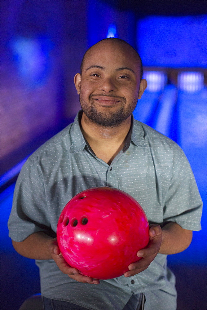 African American man who has Down Syndrome holding a bowling ball