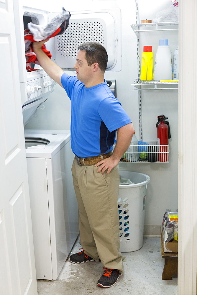 Man with Down Syndrome standing in laundry room