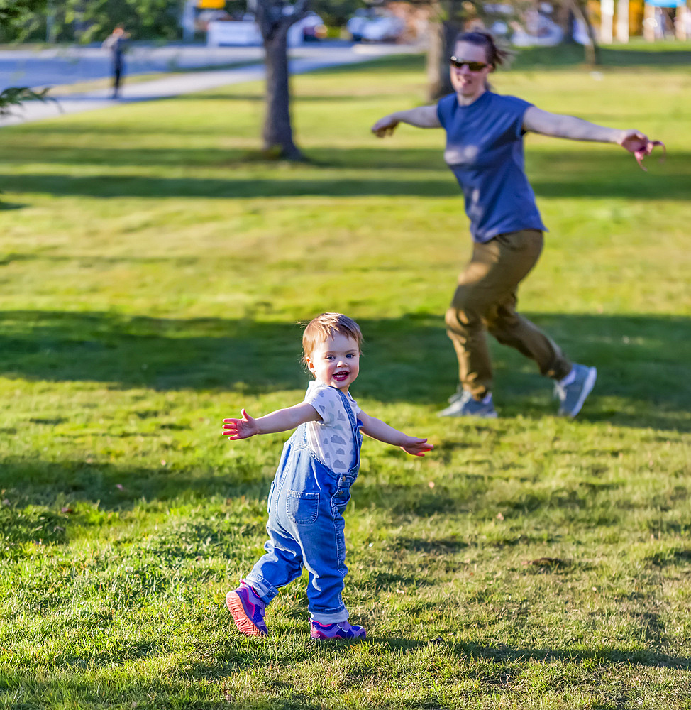 A mother plays with her toddler daughter in a park; North Vancouver, British Columbia, Canada