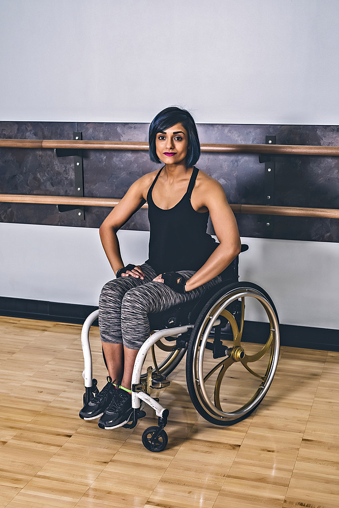 A paraplegic woman taking a break in a gymnasium after working out in a recreational facility: Sherwood Park, Alberta, Canada