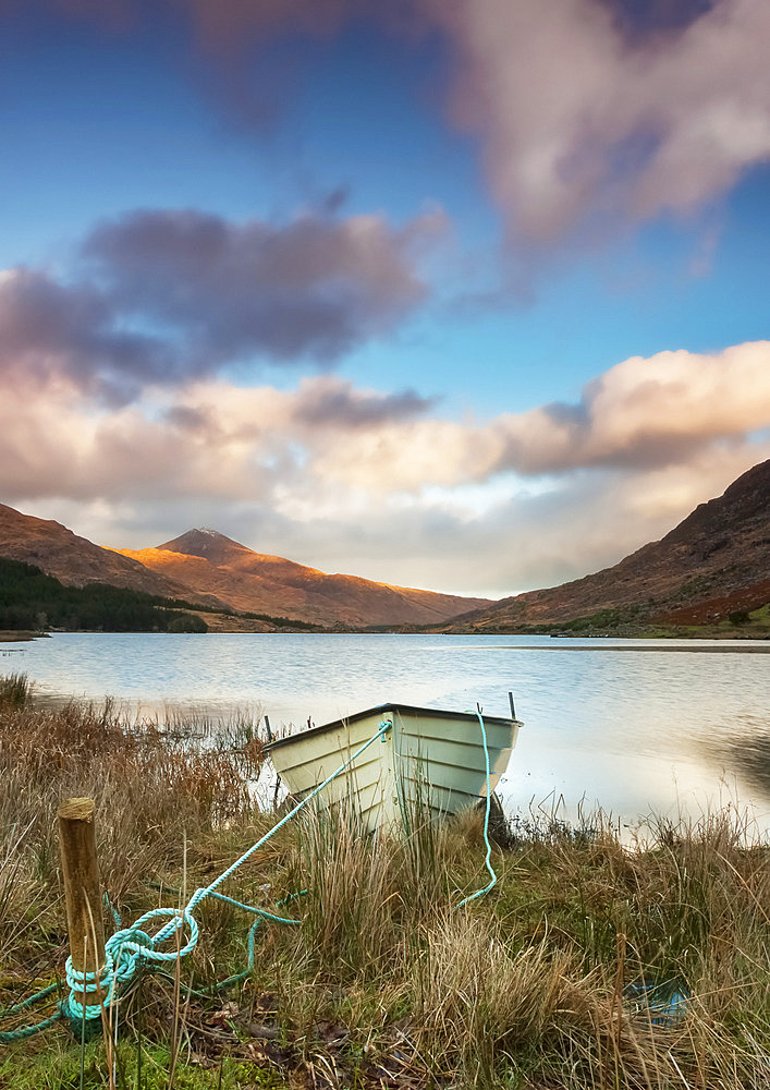 A boat on a lake shoreline with a valley and mountains in the background; Black Valley, County Kerry, Ireland