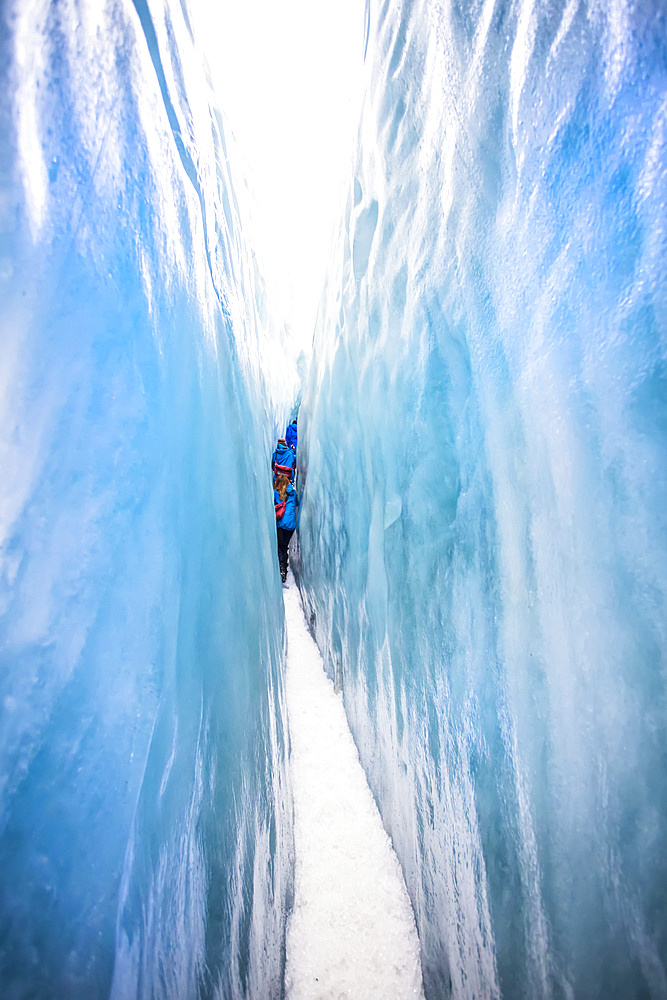 A tight squeeze for travelers exploring New Zealand's famous Franz Josef Glacier, iwth its blue Ice, deep crevasses, caves and tunnels that mark the ever changing ice formations; West Coast, New Zealand