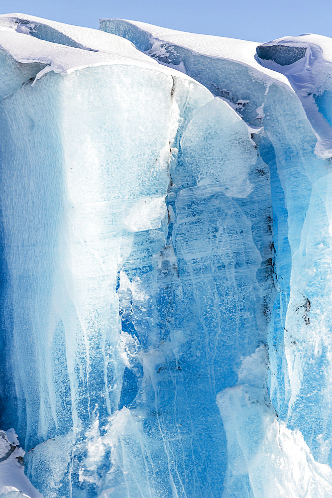 Blue ice formations on Knik glacier against a bright blue sky, Alaska, United States of America