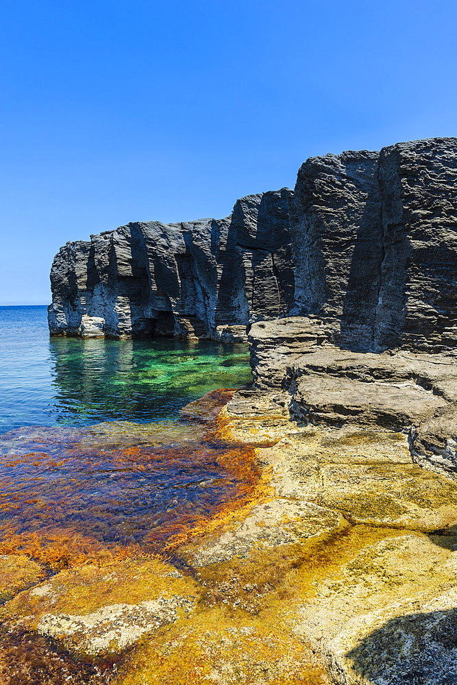 Close-up view of the volcanic rock cliffs and shoreline at Cala del Bue Marino on Pantelleria Island on a sunny day, Pantelleria Island, Trapani, Sicily, Italy