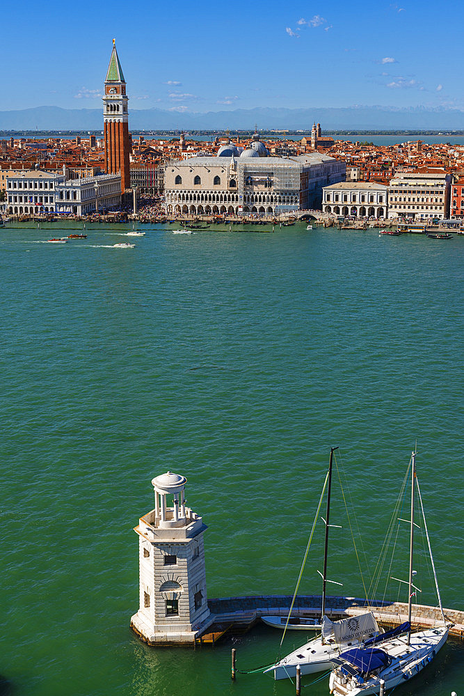 View of the Lighthouse on San Giorgio Maggiore Island looking across the waterway of Bacino Di San Marco to St Mark's Campanile, St Mark's Square, Doge's Palace on and the City of Venice Island under a blue sky, Venice, Veneto, Italy