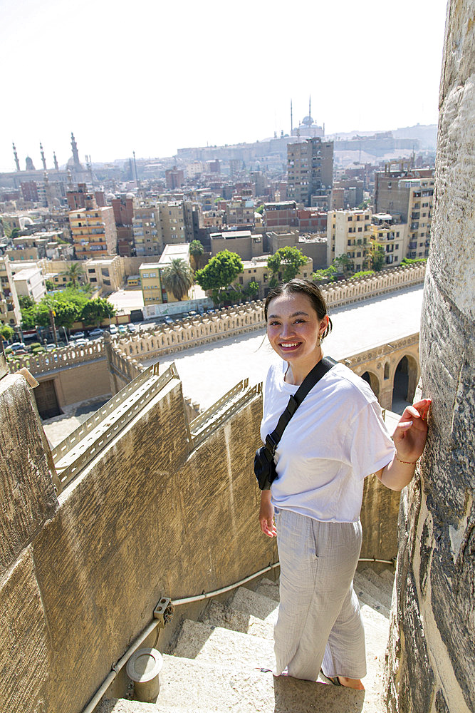 Young female tourist ascending the minaret at the Mosque of Ibn Tulun, the largest in Cairo, Egypt and one of the oldest, Cairo, Egypt